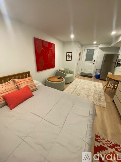 A bedroom with a large bed and a red pillow.