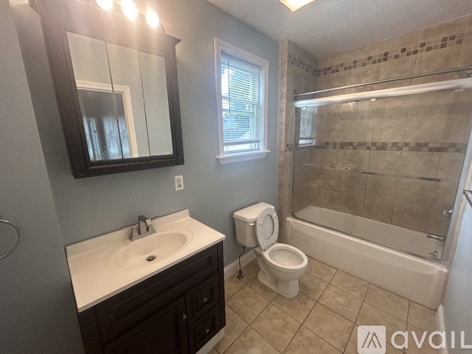 A bathroom with a toilet, sink, and shower.