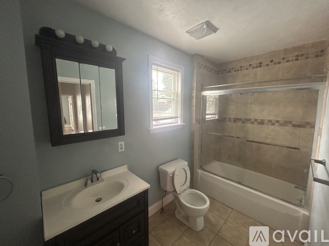 A bathroom with a toilet, sink, and bathtub.