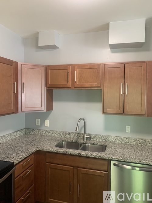 A kitchen with wooden cabinets and granite countertops.