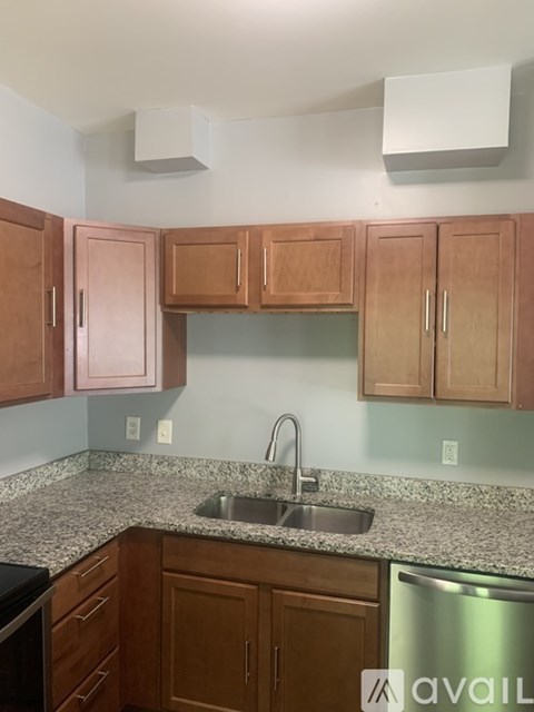 A kitchen with wooden cabinets and granite countertops.