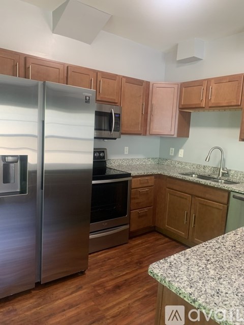 A kitchen with wooden cabinets and a granite counter.