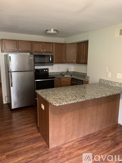 A kitchen with wooden cabinets and a granite countertop.