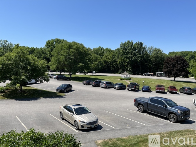 A parking lot with cars and trees in the background.
