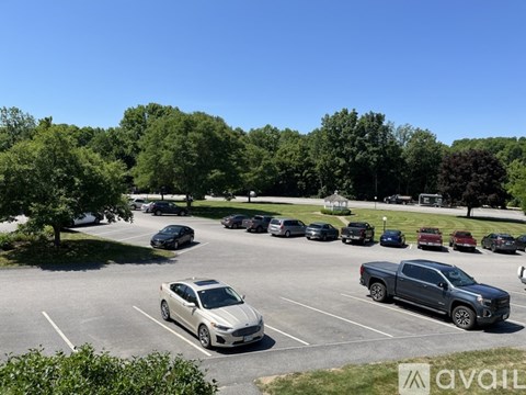 A parking lot with cars and trees in the background.