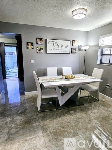 A dining room with a table and chairs.