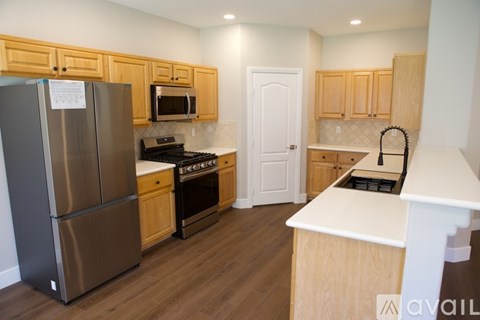 A kitchen with wooden cabinets and a stainless steel refrigerator.