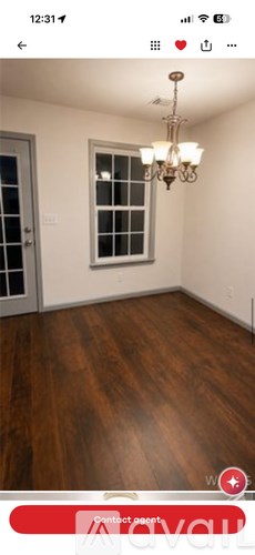 A room with wooden flooring and a chandelier.