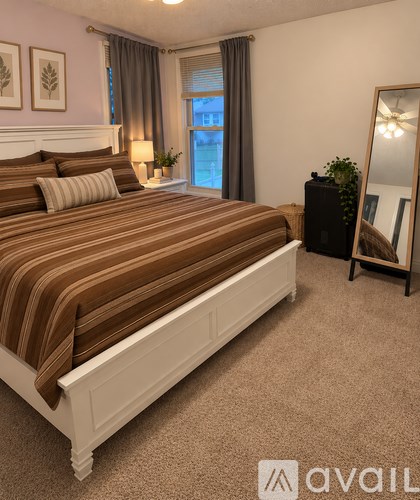 A bedroom with a large bed and a mirror on the wall.