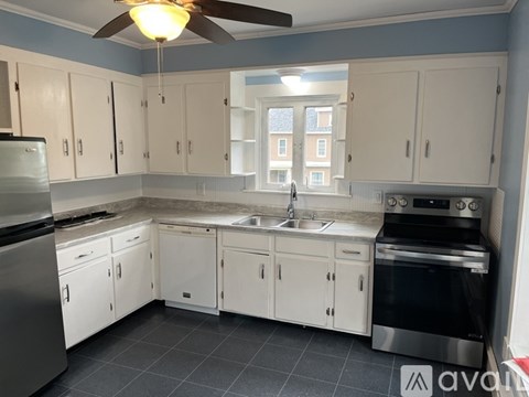 A kitchen with white cabinets and a black stove top oven.