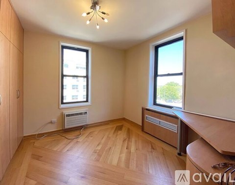 A room with wooden floors and two windows.