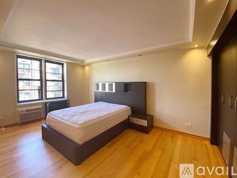 A bedroom with a large bed and a window with a view of a city.