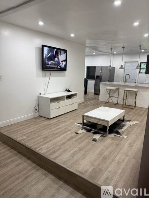 A modern living room with a flat screen TV mounted on the wall.