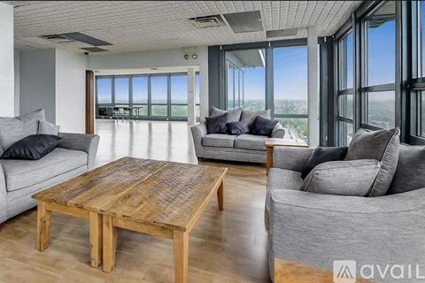 A living room with a wooden table and grey couches.