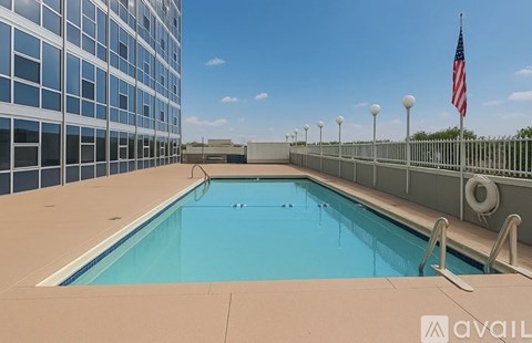 A swimming pool on a rooftop with a flag in the background.
