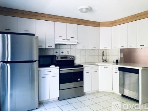 A modern kitchen with white cabinets and stainless steel appliances.