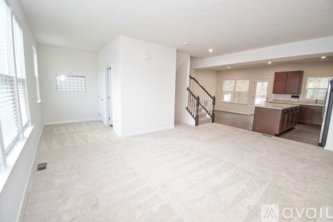 A spacious living area with a staircase leading to the upper floor.
