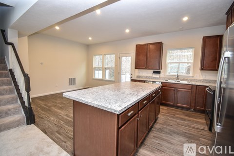 A kitchen with wooden cabinets and a marble countertop.