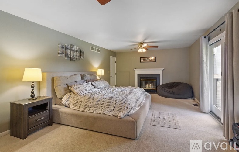 A bedroom with a large bed and a fireplace.