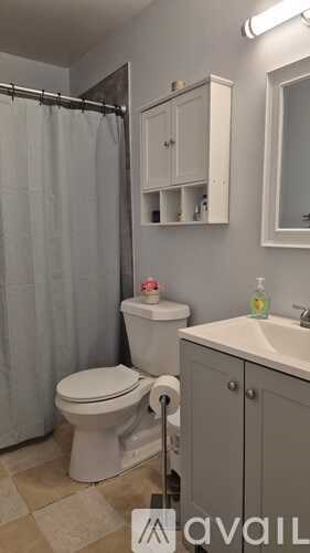 A white toilet sits in a bathroom next to a sink.