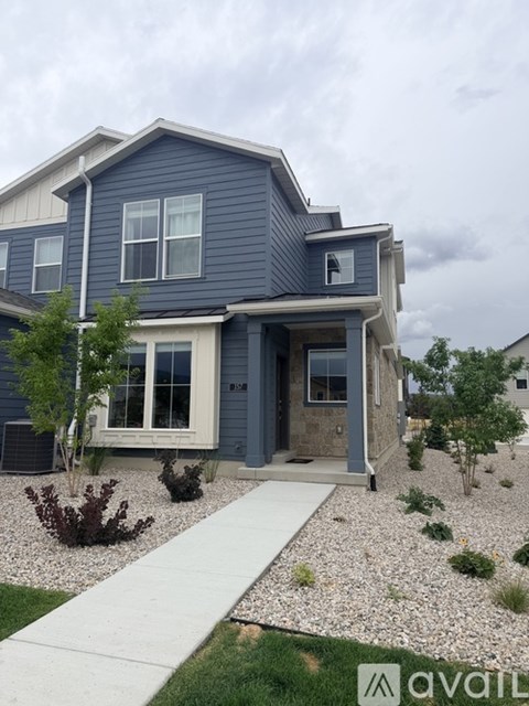 A house with a blue exterior and a white walkway leading to the front door.