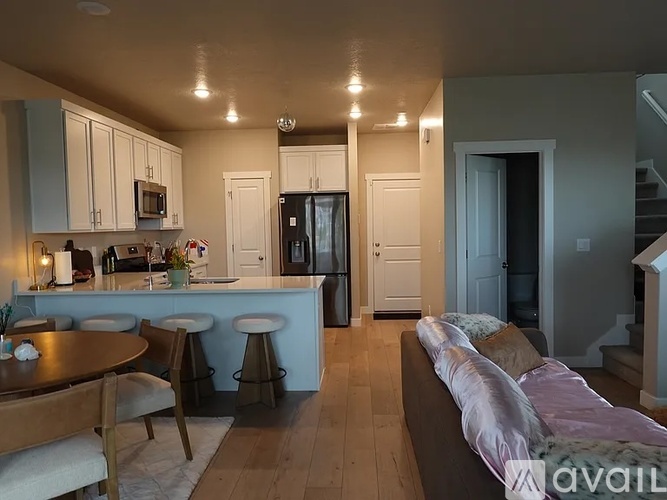 A kitchen with a table and chairs and a couch.
