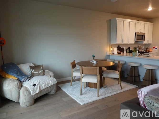 A living room with a couch, chairs, and a dining table.