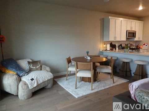A living room with a couch, chairs, and a dining table.