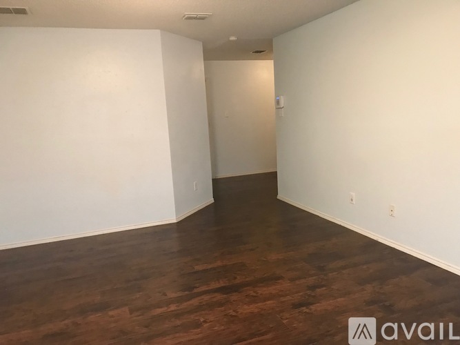 A room with wooden flooring and white walls.