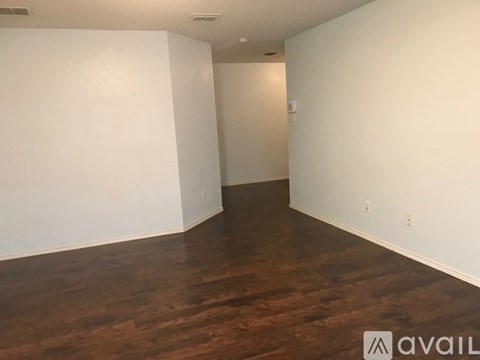 A room with wooden flooring and white walls.
