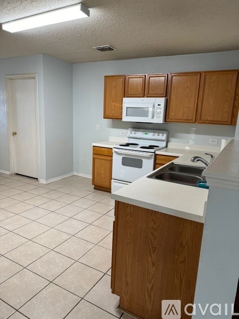 A kitchen with wooden cabinets and a white microwave.