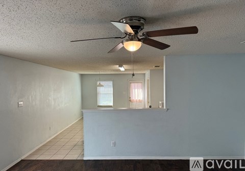 A room with a ceiling fan and a window with blinds.