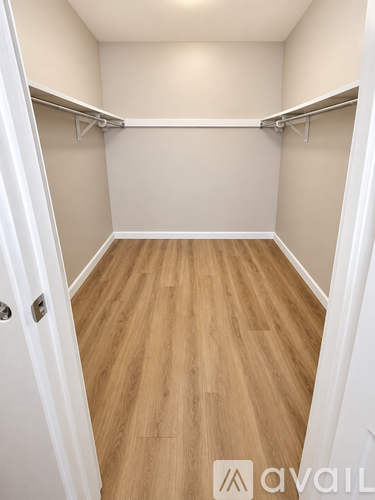 A small, empty room with wooden floors and white walls.