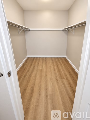 A small, empty room with wooden floors and white walls.