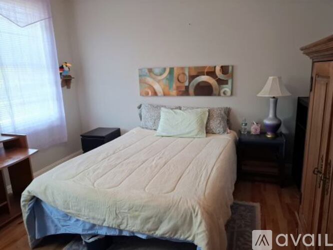 A bedroom with a bed, nightstand, and lamp.