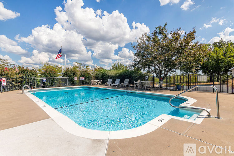 A swimming pool surrounded by a fence with a flag on top.