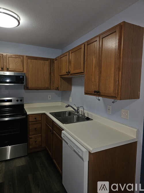A kitchen with wooden cabinets and a white countertop.