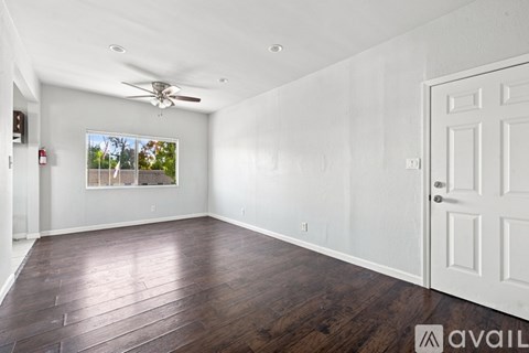 A room with a ceiling fan and a door.