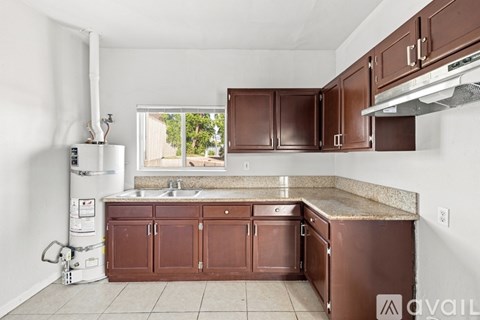 A kitchen with brown cabinets and a granite countertop.