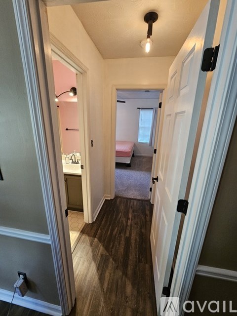 A hallway with a light on the ceiling and a door on the right.