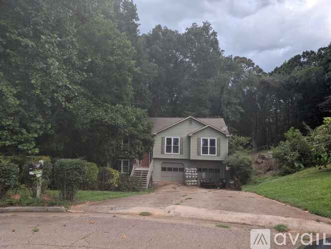 A house is for sale in a wooded area.