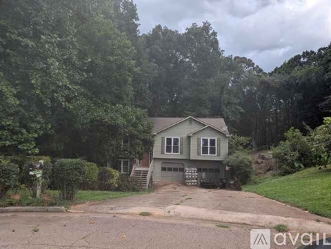 A house is for sale in a wooded area.