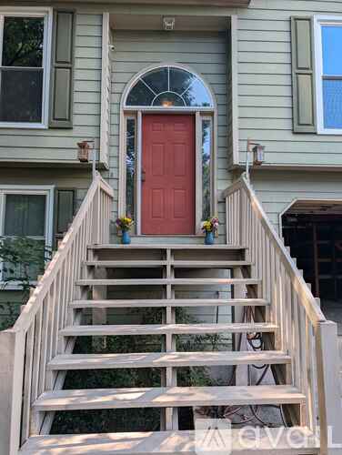 A house with a red door and a wooden staircase leading to it.