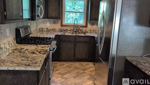 A kitchen with granite countertops and a checkered floor.