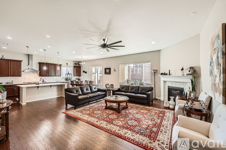 A spacious living room with a fireplace and a rug on the floor.