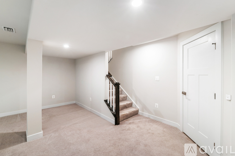A spacious room with a staircase leading to the upper floor.