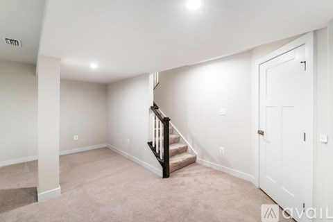 A spacious room with a staircase leading to the upper floor.