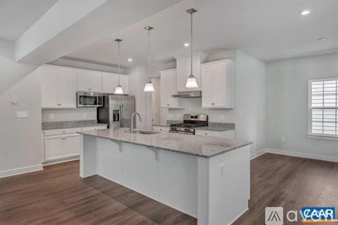 A modern kitchen with white cabinets and a central island.