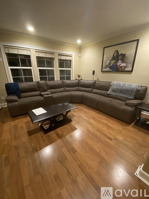 A living room with a brown sectional sofa and a coffee table.