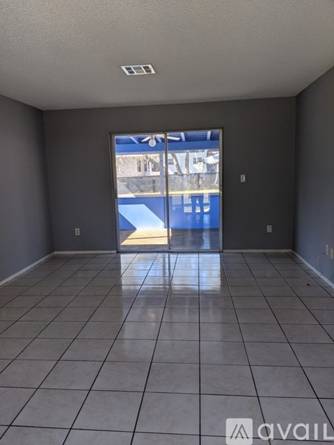 A room with a tiled floor and a sliding glass door leading outside.